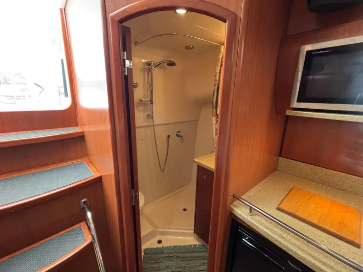 Sawbones Yacht Photos Pics Interior of 2011 Luhrs 37 Canyon IPS yacht, featuring a compact shower and kitchenette.