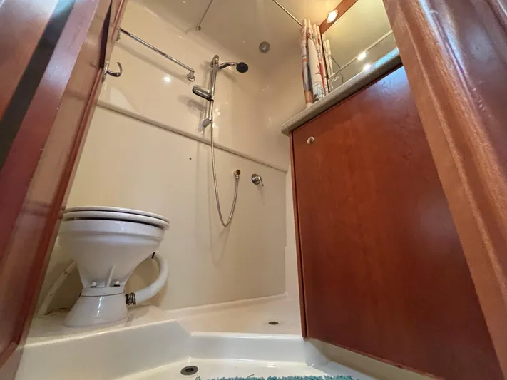 Sawbones Yacht Photos Pics 2011 Luhrs 37 Canyon IPS bathroom with shower, toilet, and wooden cabinetry.