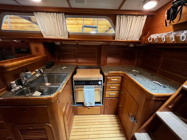 Symphony V Yacht Photos Pics 1999 Hinckley Sou'wester 52 yacht kitchen with wooden cabinetry and granite countertops.