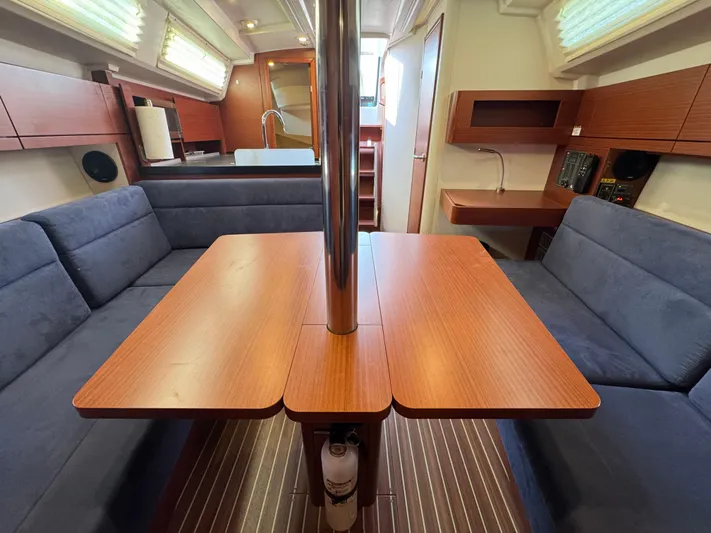 Dreamcatcher Yacht Photos Pics 2018 Hanse 348 yacht interior with wooden table, blue seating, and modern kitchen area.