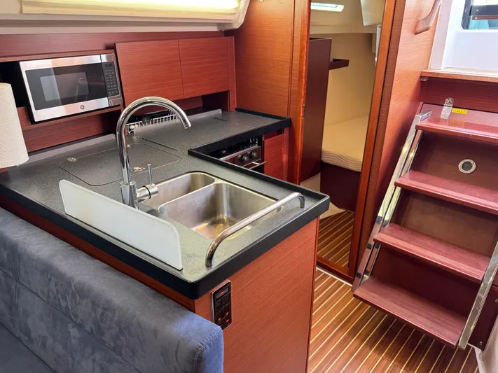Dreamcatcher Yacht Photos Pics Modern 2018 Hanse 348 yacht interior with kitchen, sink, and wooden stairs.