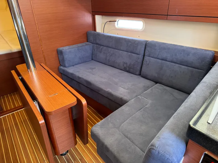 Dreamcatcher Yacht Photos Pics Interior of 2018 Hanse 348 yacht with blue sofa and wooden accents.