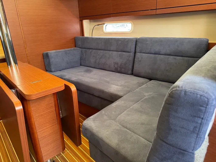 Dreamcatcher Yacht Photos Pics 2018 Hanse 348 yacht interior with blue sofa and wooden table.