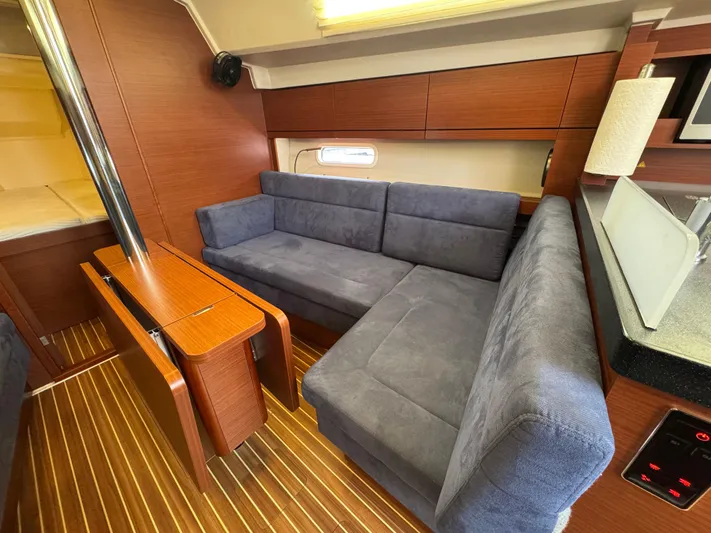 Dreamcatcher Yacht Photos Pics Interior of 2018 Hanse 348 yacht with blue sofa and wooden accents.