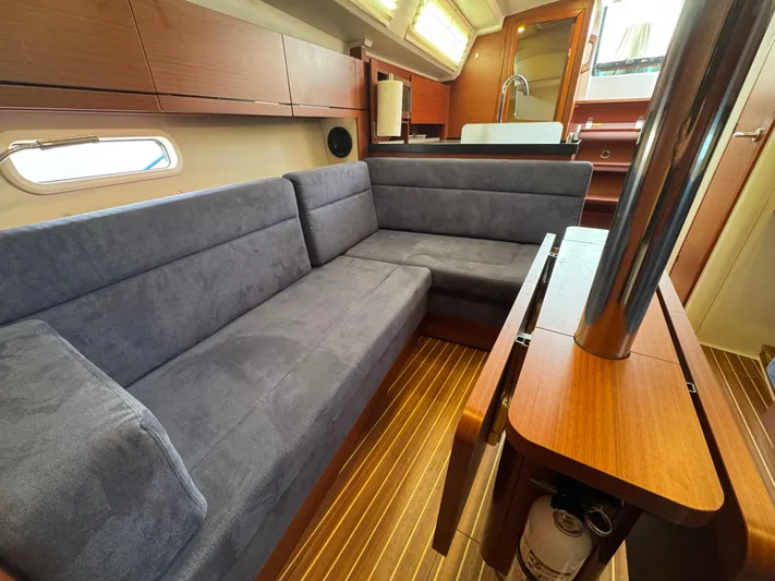 Dreamcatcher Yacht Photos Pics 2018 Hanse 348 interior with blue seating, wooden flooring, and modern kitchen area.