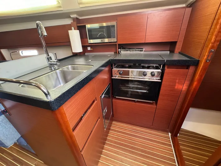 Dreamcatcher Yacht Photos Pics Modern kitchen in 2018 Hanse 348 yacht with wood cabinetry and stainless steel appliances.