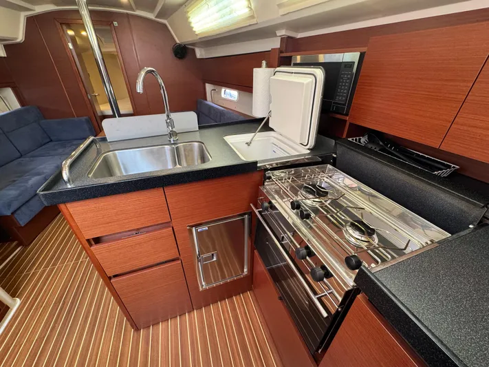 Dreamcatcher Yacht Photos Pics 2018 Hanse 348 yacht interior kitchen with stove, sink, and wooden cabinetry.