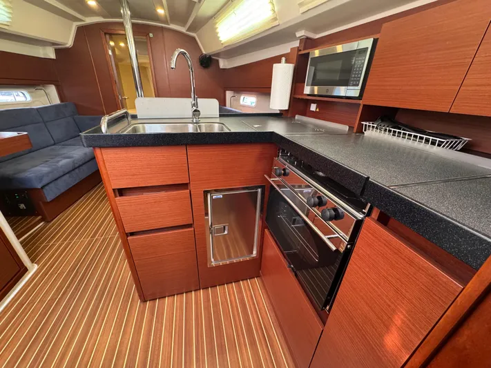 Dreamcatcher Yacht Photos Pics Modern kitchen interior of 2018 Hanse 348 yacht with wood finish and appliances.