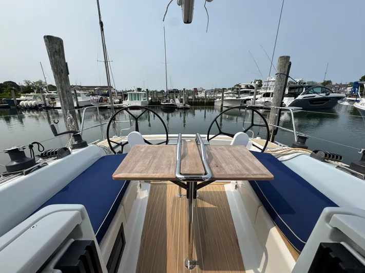 Dreamcatcher Yacht Photos Pics 2018 Hanse 348 sailboat cockpit with dual steering wheels and wooden table, docked at marina.