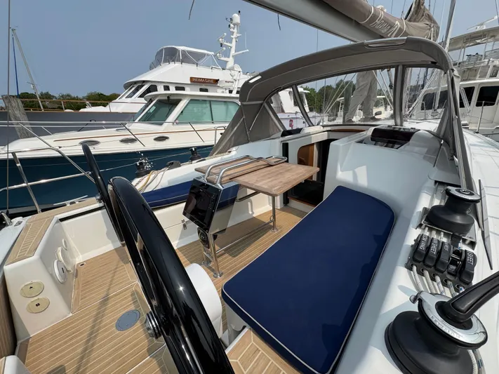 Dreamcatcher Yacht Photos Pics 2018 Hanse 348 yacht cockpit with blue seating and wooden table, docked at marina.