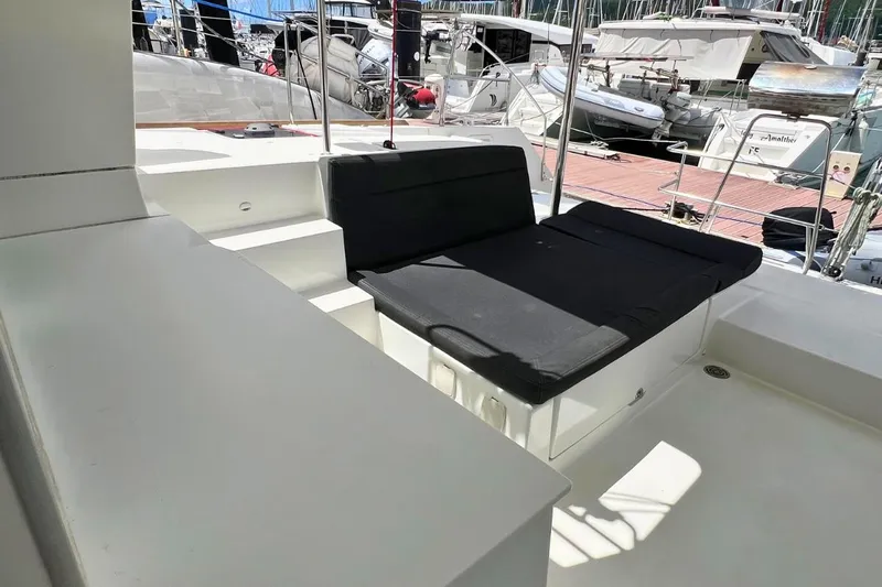 Take It Easy Yacht Photos Pics 2018 Lagoon 450 F yacht interior with black cushioned seating and marina view.