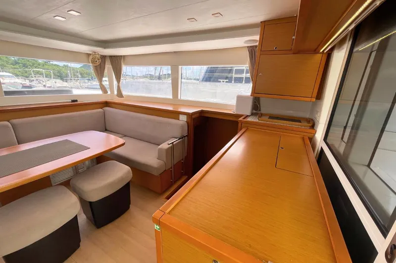 Take It Easy Yacht Photos Pics Interior of 2018 Lagoon 450 F catamaran with spacious seating and wooden cabinetry.