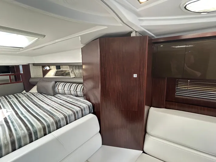 Aguabendita Yacht Photos Pics Interior of 2019 Monterey 345 Sport Yacht with striped bedding and sleek wood finishes.