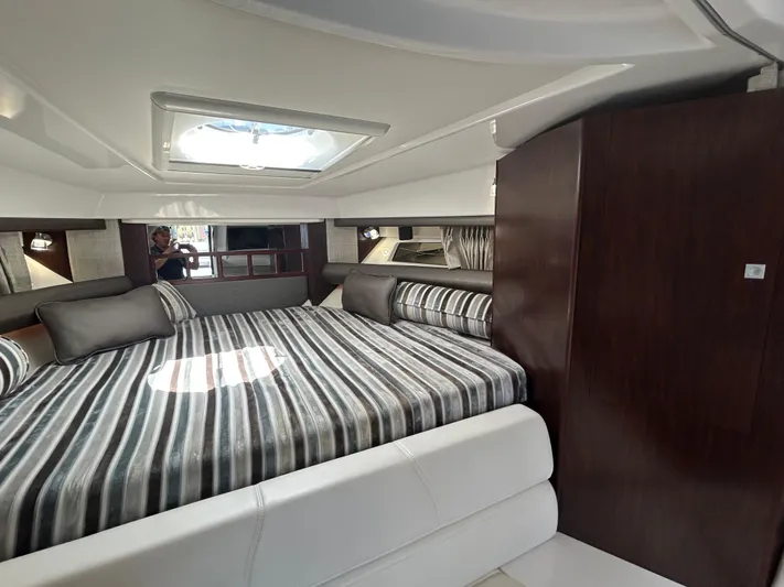 Aguabendita Yacht Photos Pics Luxurious interior of 2019 Monterey 345 Sport Yacht with striped bedding and skylight.