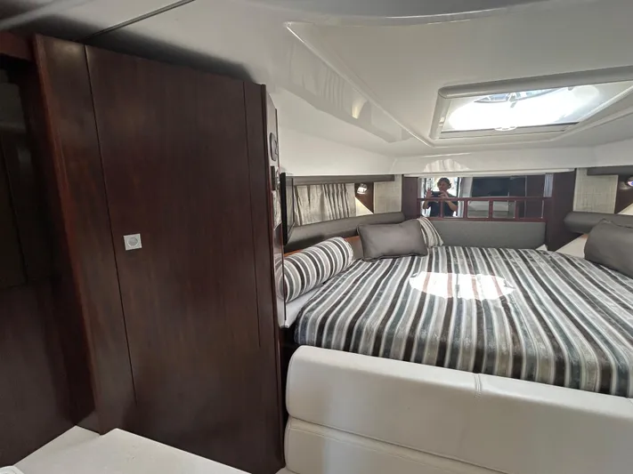 Aguabendita Yacht Photos Pics Interior of 2019 Monterey 345 Sport Yacht with striped bedding and modern design.