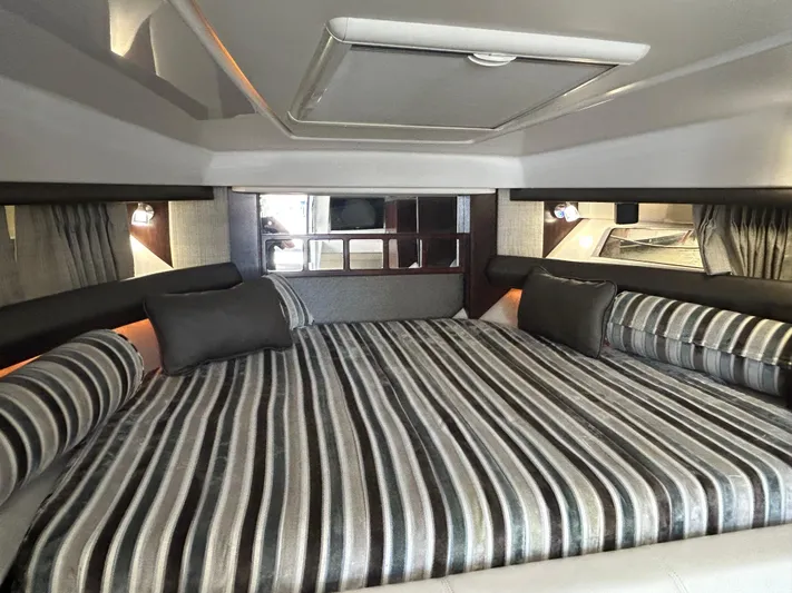 Aguabendita Yacht Photos Pics Luxurious interior of 2019 Monterey 345 Sport Yacht with striped bedding and modern lighting.
