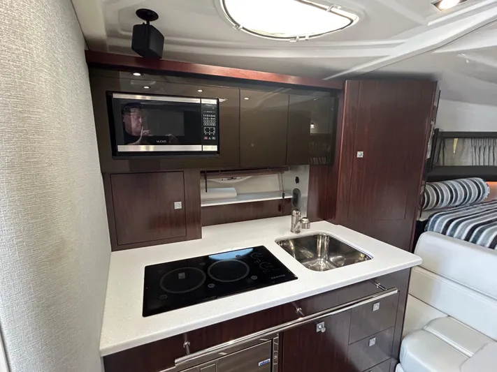 Aguabendita Yacht Photos Pics 2019 Monterey 345 Sport Yacht kitchen with microwave, stove, sink, and modern cabinetry.