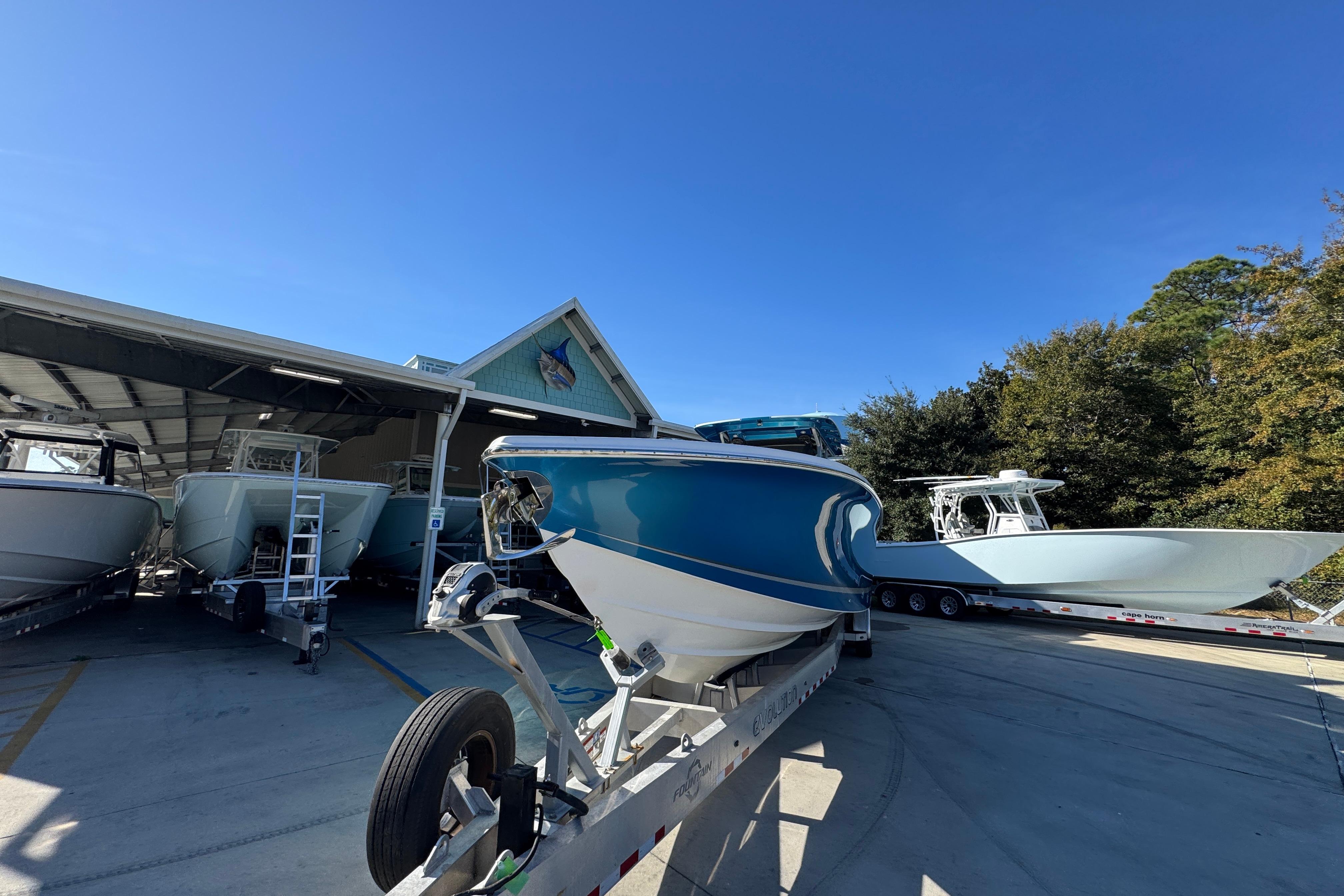 2016 Nor-Tech 390 Sport Center Console boats on trailers at a marina under clear blue skies.