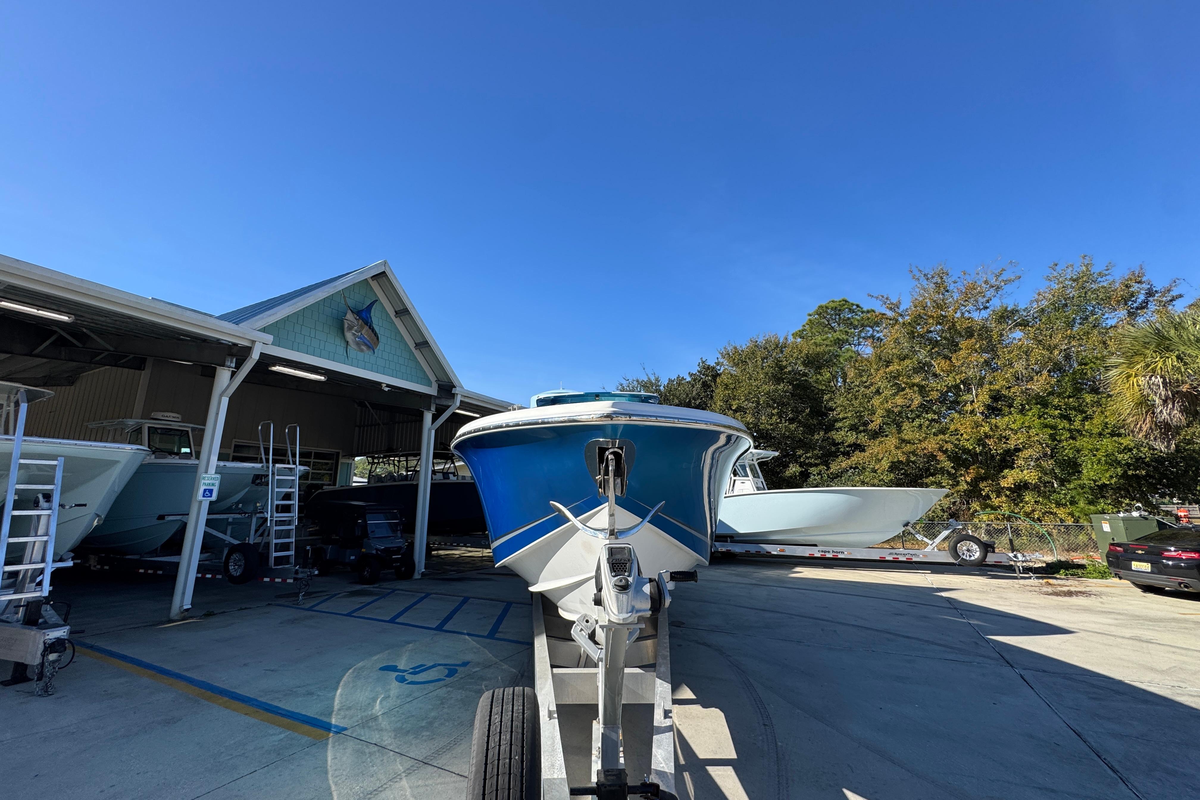 2016 Nor-Tech 390 Sport Center Console boat on trailer at marina under clear blue sky.