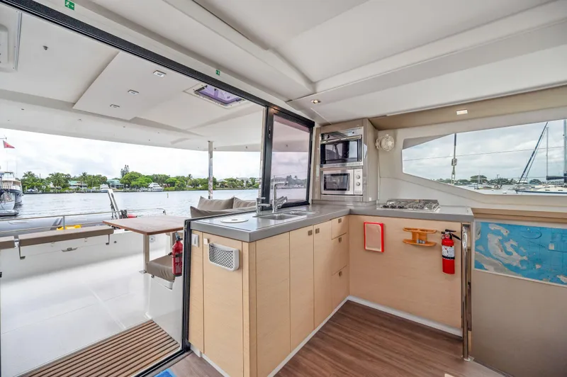 Sabai Sabai Yacht Photos Pics Modern kitchen interior of 2018 Fountaine Pajot Lucia 40 catamaran with waterfront view.