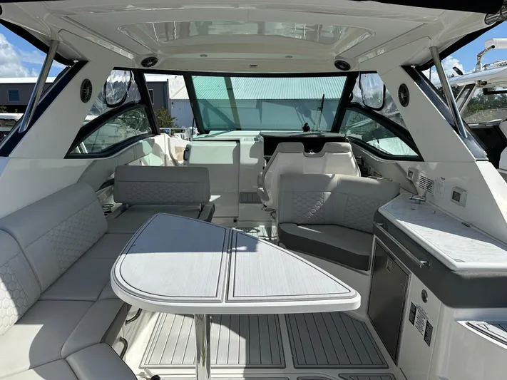  Yacht Photos Pics 2022 Sea Ray Sundancer 320 interior with seating, table, and kitchenette.