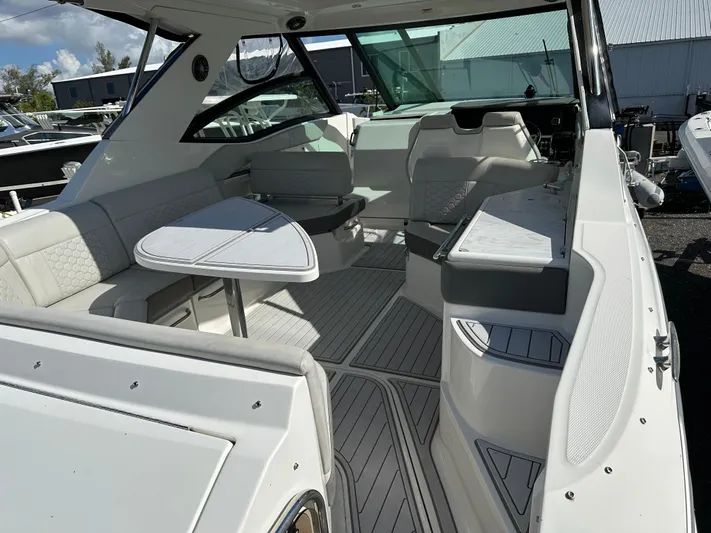  Yacht Photos Pics 2022 Sea Ray Sundancer 320 interior with seating and table, showcasing modern design and comfort.