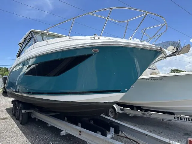  Yacht Photos Pics 2022 Sea Ray Sundancer 320 boat on trailer, blue hull, parked outdoors.