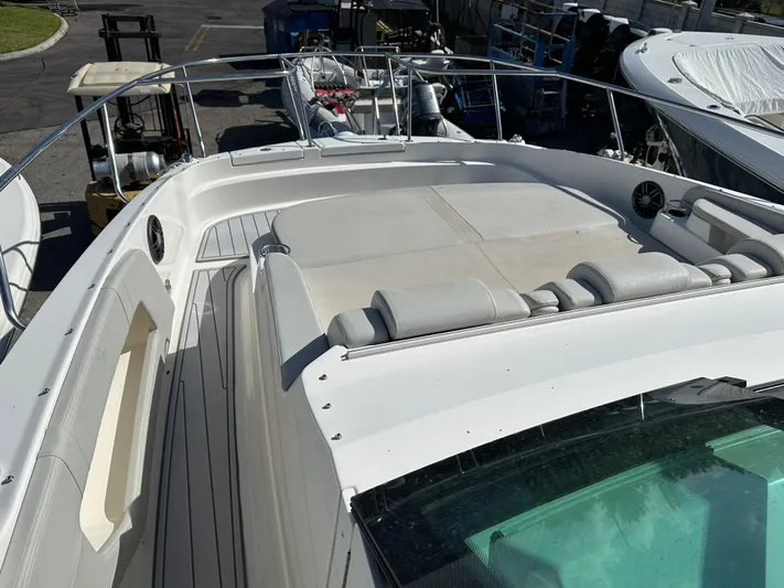  Yacht Photos Pics 2022 Sea Ray Sundancer 320 boat deck with seating and railing in a marina.