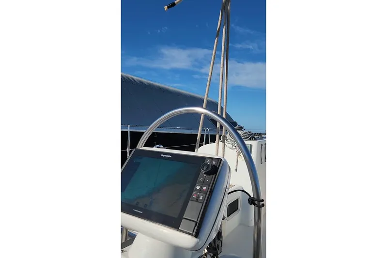  Yacht Photos Pics Beneteau First 44.7 yacht helm with navigation system, 2005 model, under clear blue sky.