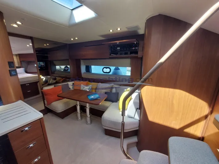  Yacht Photos Pics Luxurious interior of 2020 Princess V50 yacht with cozy seating and elegant wood finishes.