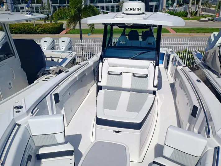332-299 Yacht Photos Pics 2025 Blackfin 332 CC boat interior with seating and Garmin equipment, docked outdoors.