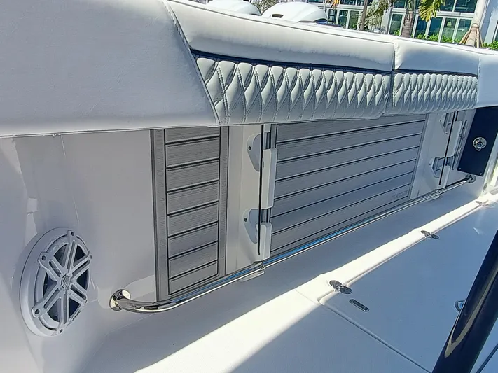 332-299 Yacht Photos Pics 2025 Blackfin 332 CC boat interior with cushioned seating and speaker detail.