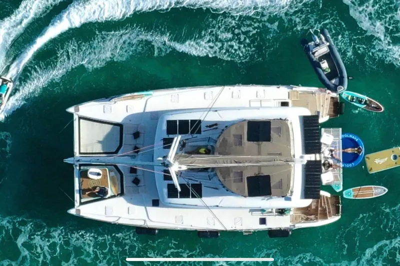  Yacht Photos Pics Aerial view of 2018 Lagoon 620 catamaran with water activities in turquoise sea.