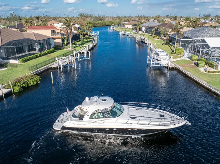 Jo's Diamond Yacht Photos Pics 2004 Sea Ray 500 Sundancer cruising through a scenic residential canal.