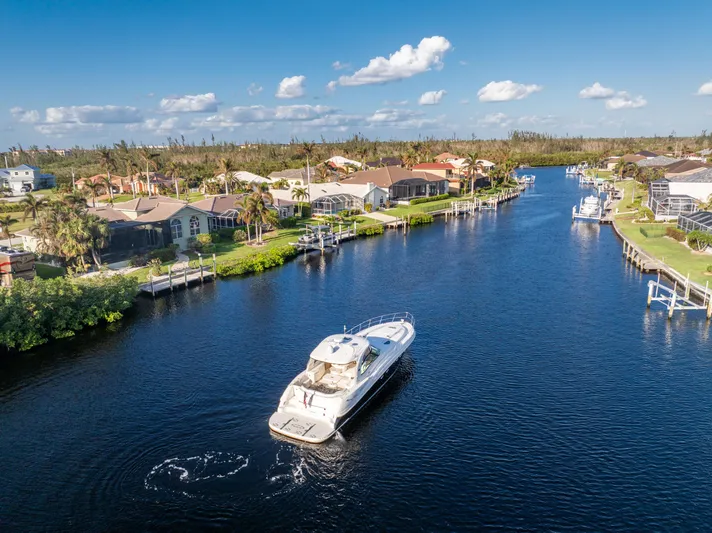 Jo's Diamond Yacht Photos Pics 2004 Sea Ray 500 Sundancer cruising in a scenic residential canal.