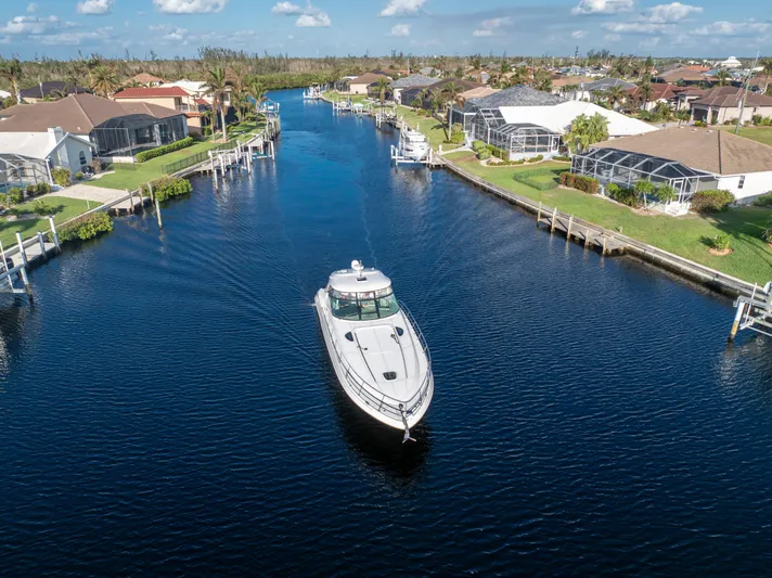 Jo's Diamond Yacht Photos Pics Sea Ray 500 Sundancer 2004 cruising through a scenic residential canal.