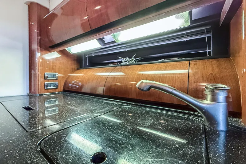 Jo's Diamond Yacht Photos Pics Luxurious kitchen area in 2004 Sea Ray 500 Sundancer yacht with sleek countertops and modern fixtures.