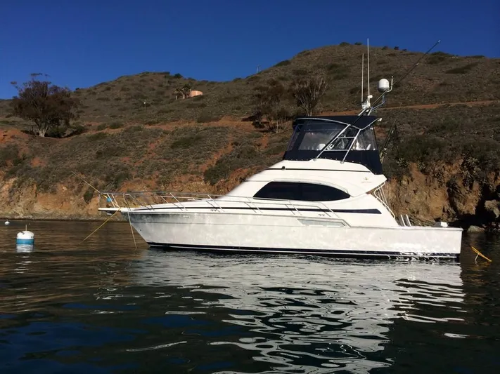 Mai Time Yacht Photos Pics 2001 Bertram 390 Convertible yacht anchored near rocky coastline.