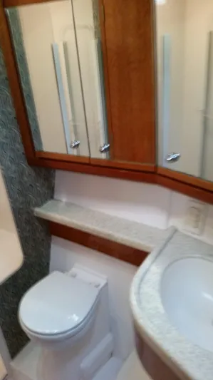 Mai Time Yacht Photos Pics 2001 Bertram 390 Convertible yacht bathroom with modern fixtures and mirrored cabinets.