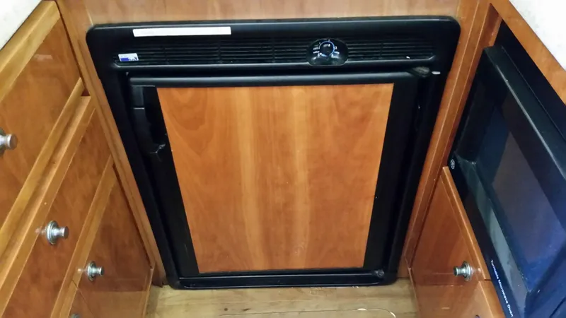 Mai Time Yacht Photos Pics Wood-paneled refrigerator in 2001 Bertram 390 Convertible yacht kitchen.