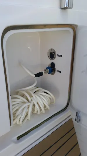 Mai Time Yacht Photos Pics Coiled hose in storage compartment of 2001 Bertram 390 Convertible boat.