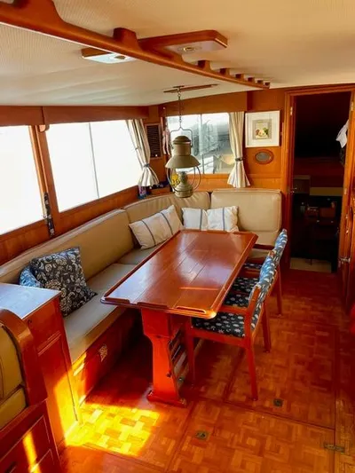 Padre Pio Yacht Photos Pics 1986 Grand Banks 42 Classic interior with wooden dining area and cushioned seating.