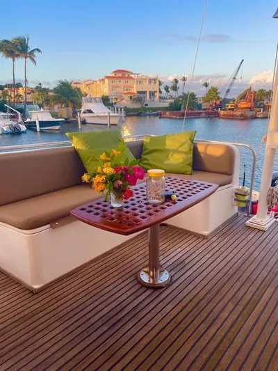Padre Pio Yacht Photos Pics Grand Banks 42 Classic 1986 yacht deck with seating, table, and vibrant flowers.
