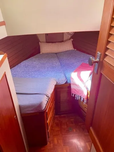 Padre Pio Yacht Photos Pics Cozy cabin interior of 1986 Grand Banks 42 Classic with wooden furnishings and bed.