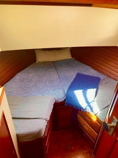 Padre Pio Yacht Photos Pics Cozy cabin interior of 1986 Grand Banks 42 Classic yacht with bed and wooden paneling.