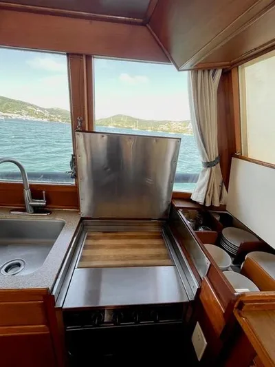 Padre Pio Yacht Photos Pics 1986 Grand Banks 42 Classic yacht kitchen with ocean view, featuring sink and stove.