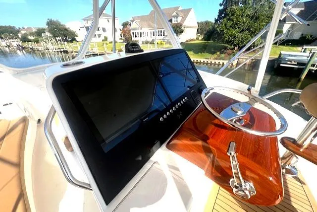  Yacht Photos Pics 2024 Custom Carolina Albemarle Spencer boat helm with modern controls and wooden steering wheel.