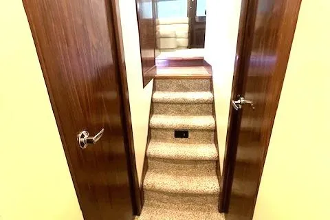  Yacht Photos Pics Interior stairs of 2024 Custom Carolina Albemarle Spencer yacht, featuring wooden doors and carpeted steps.