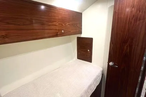  Yacht Photos Pics 2024 Custom Carolina Albemarle Spencer cabin interior with wood paneling and bed.