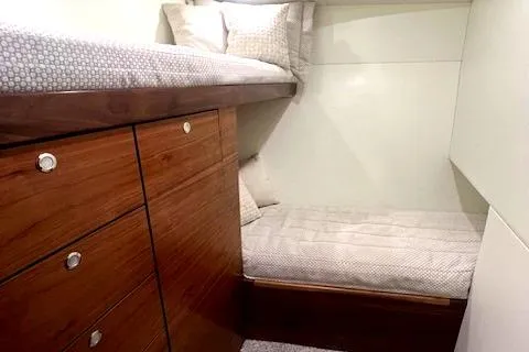  Yacht Photos Pics 2024 Custom Carolina Albemarle Spencer cabin with wooden drawers and cozy bedding.